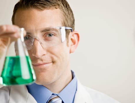 Young male scientist examining fluid. Horizontally framed shot.