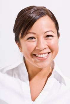 A headshot of an attractive young asian woman. She is smiling directly at the camera. Vertically framed shot.