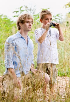 Father and son using binoculars