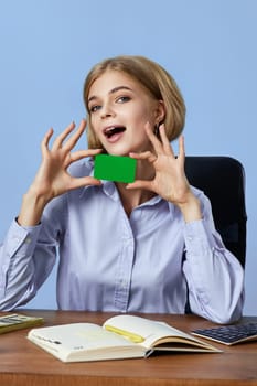 very excited business woman holding plastic credit card on blue background