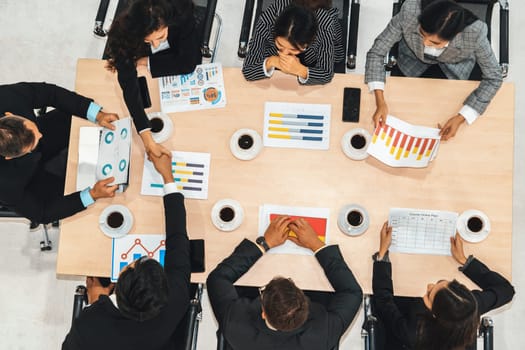 Business people group meeting shot from top view in office . Profession businesswomen, businessmen and office workers working in team conference with project planning document on meeting table . Jivy