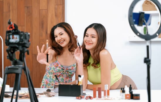 Woman influencer shoot live streaming vlog video review makeup uttermost social media or blog. Happy young girl with cosmetics studio lighting for marketing recording session broadcasting online.