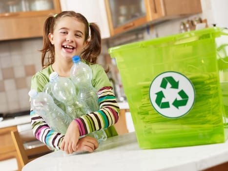 Girl looking at camera and holding plastic bottles for recycling