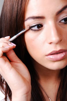 Young woman putting makeup.