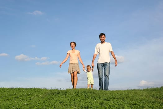 family with baby walking on grass