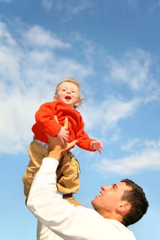 baby in sky on father's hands