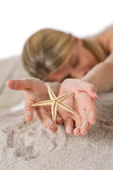 Beach - woman holding starfish lying in sand