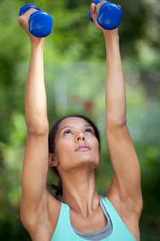 Young woman exercising in outdoor setting. Vertically framed shot.