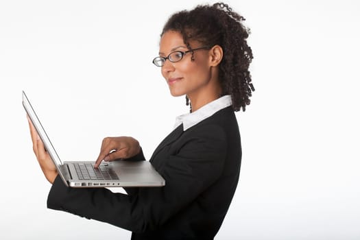 Young businesswoman in profile using laptop. Horizontally framed shot.