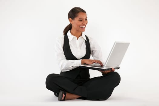 Young woman sitting on floor using laptop. Horizontally format.