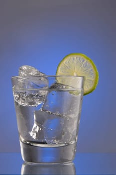 Club Soda on the rocks with lime slice garnish on plain background