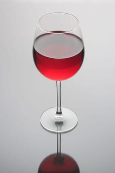 Red wine in a glass on a plain grey background
