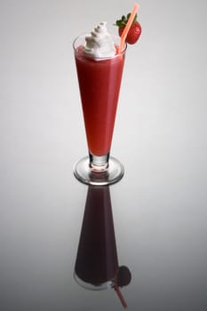 Frozen strawberry Daiguiri mixed drink with whipped cream and fruit garnish on plain background with eflection