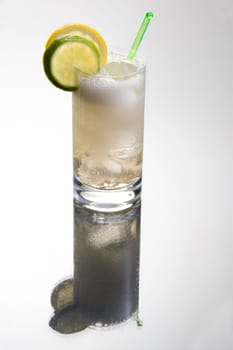 Gin or vodka tonic with lemon and lime sleces garnish on grey background with reflection