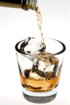 Whiskey poured on the rocks in an empty old fashioned glass on a white background