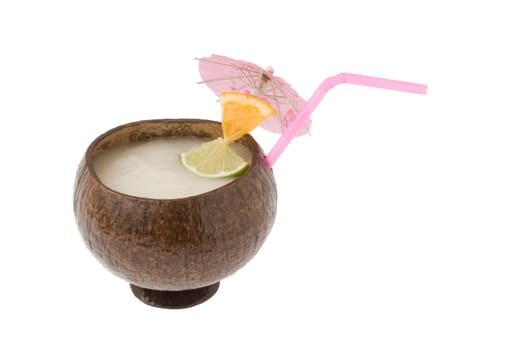 Pina Colada mixed drink with fruit garnish in a cocoanut container on white background