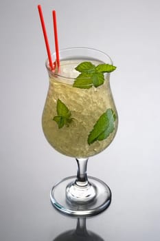 Mint Julep mixed drink on grey background with reflection