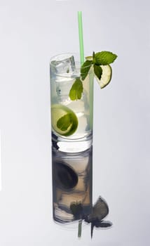 mojito mixed drink on a plain grey background with reflection