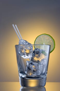 Club Soda on the rocks with lime slice garnish on plain background