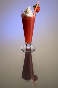 Frozen strawberry Daiguiri mixed drink with whipped cream and fruit garnish on plain background with eflection