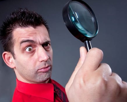 Funny businessman with magnifying glass