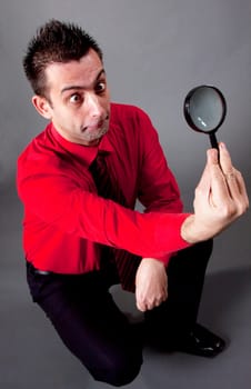 Funny businessman with magnifying glass