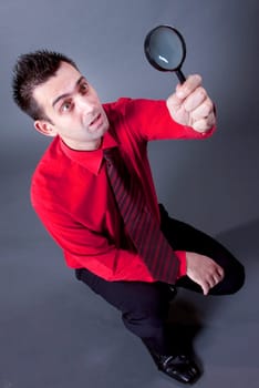 Funny businessman with magnifying glass