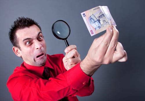Funny businessman looking at banknote
