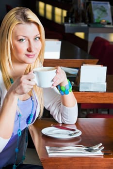 woman sitting on sofa and having coffee