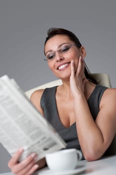 Thoughtful businesswoman read newspaper at office