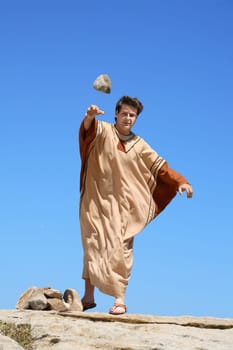 Man picking up rock or making rock pile.