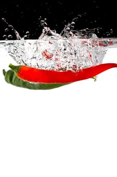 Red and green hot peppers in water