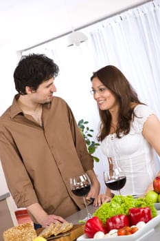 Happy couple drink red wine in modern kitchen