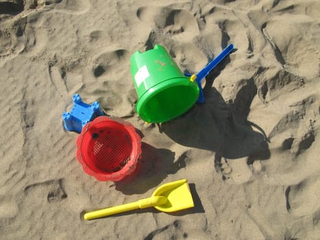 Colorful children's toys on sandy beach