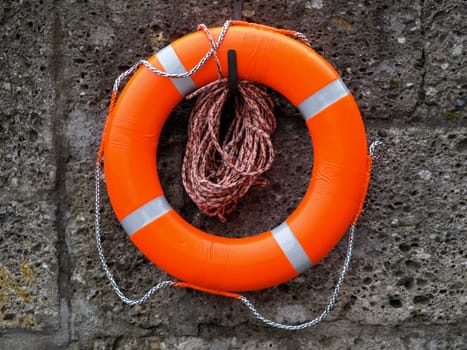 Orange lifebuoy on a concrete wall