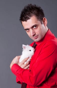 Handsome young man holding baby rabbit