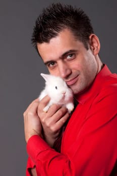 Handsome young man holding baby rabbit