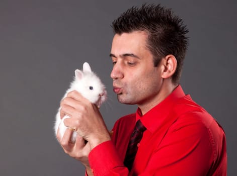 Handsome young man holding baby rabbit