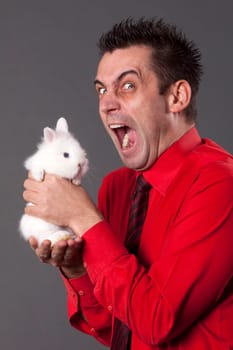Funny young man holding baby rabbit
