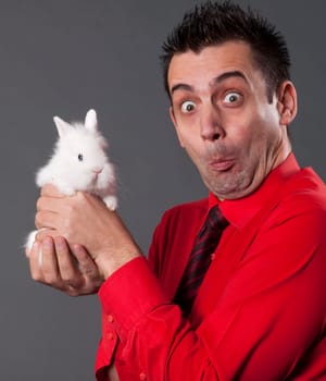 Funny young man holding baby rabbit