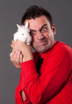 Funny young man holding baby rabbit