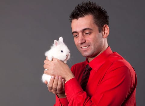 Handsome young man holding baby rabbit