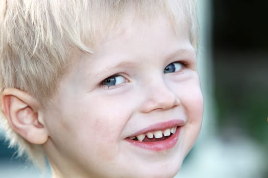 Young, happy blond boy laughs