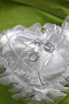 wedding rings on a white ring pillow