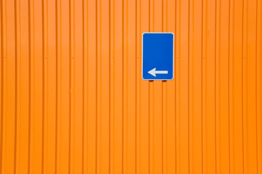 Blue sign on orange steel wall