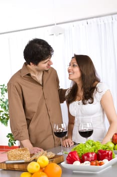 Happy couple in modern kitchen with red wine