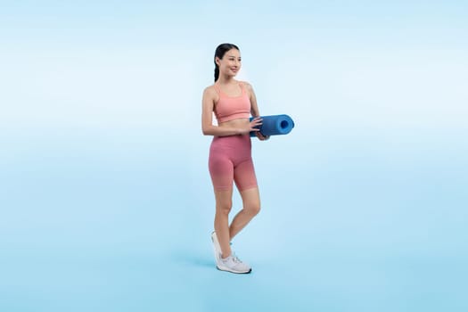 Young attractive asian woman portrait in sportswear with exercising mat. Healthy exercise and workout routine lifestyle concept. Studio shot isolated background. Vigorous