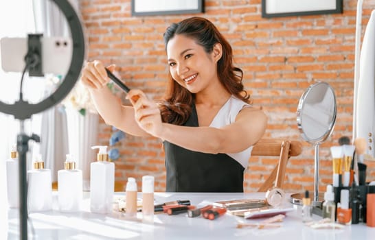 Woman influencer shoot live streaming vlog video review makeup uttermost social media or blog. Happy young girl with cosmetics studio lighting for marketing recording session broadcasting online.