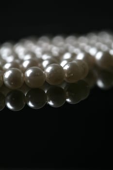 Beautiful white pearl necklace over black background