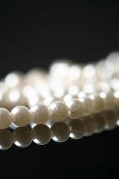 Beautiful white pearl necklace over black background